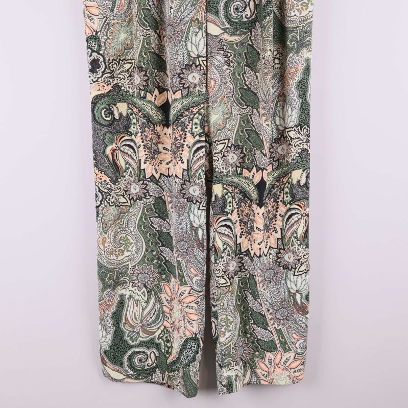 Närbild på byxbenen med paisleymönster och bred passform