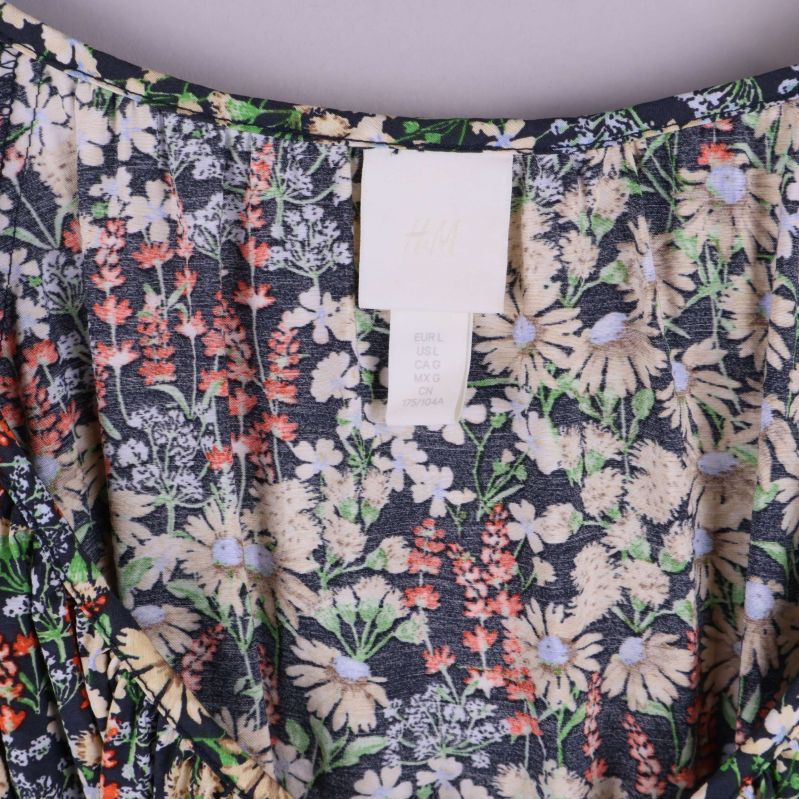 Närbild på hals och etikett av blommig klänning