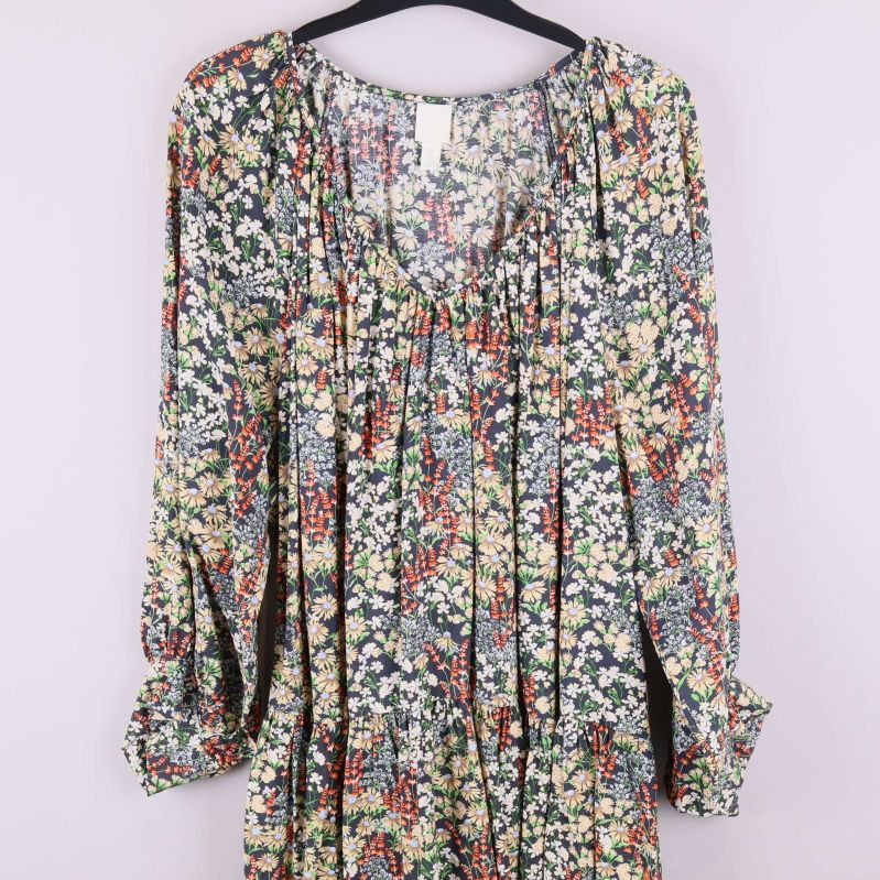 Närbild på överdel av blommig klänning