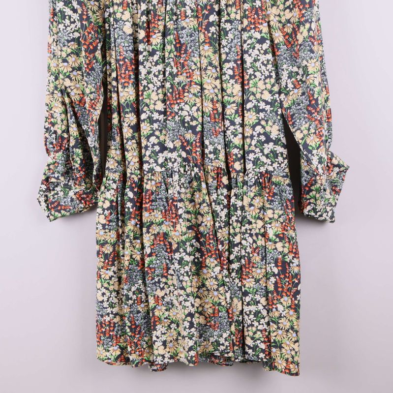 Närbild på nederdel och ärmslut av blommig klänning