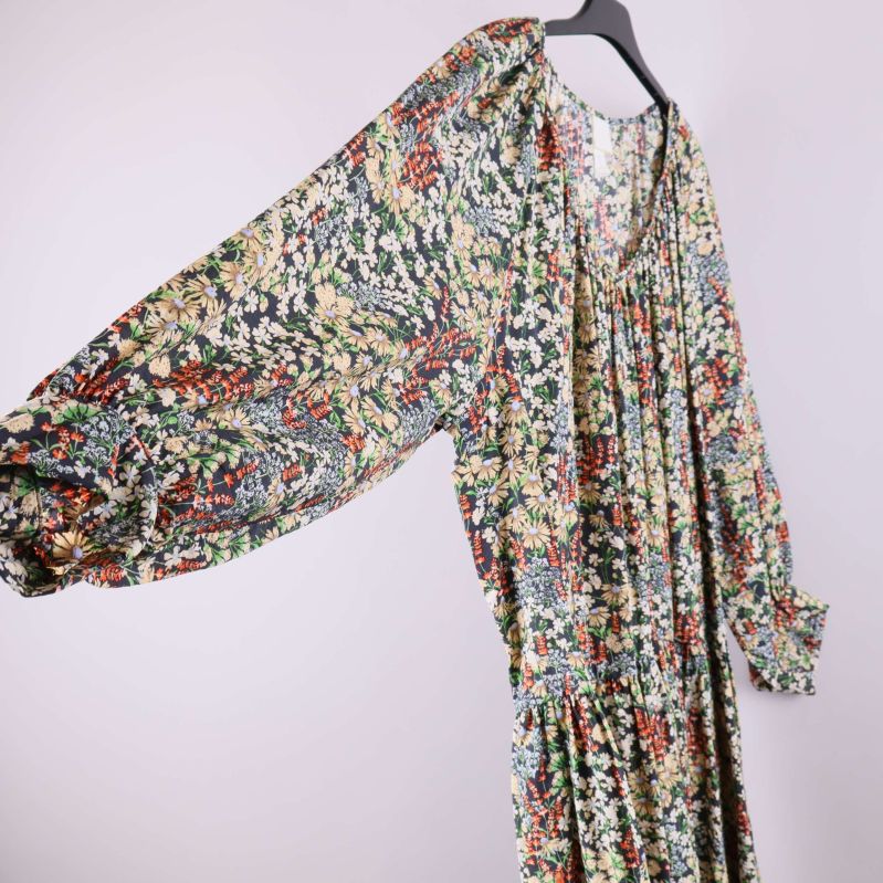 Blommig klänning med utsvängda ärmar i sidovy