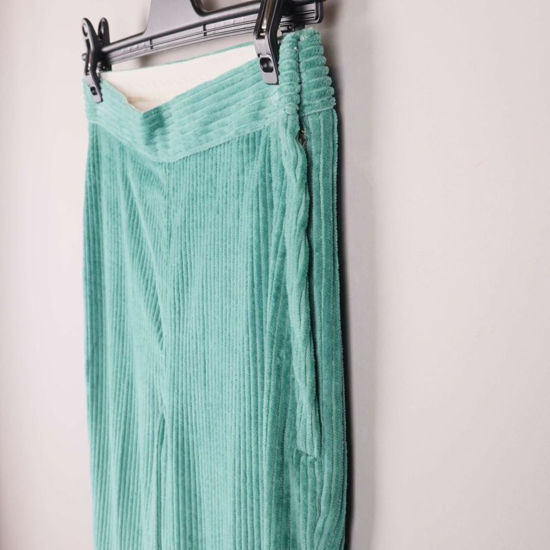 Sidovy på gröna byxor med synlig resår och struktur