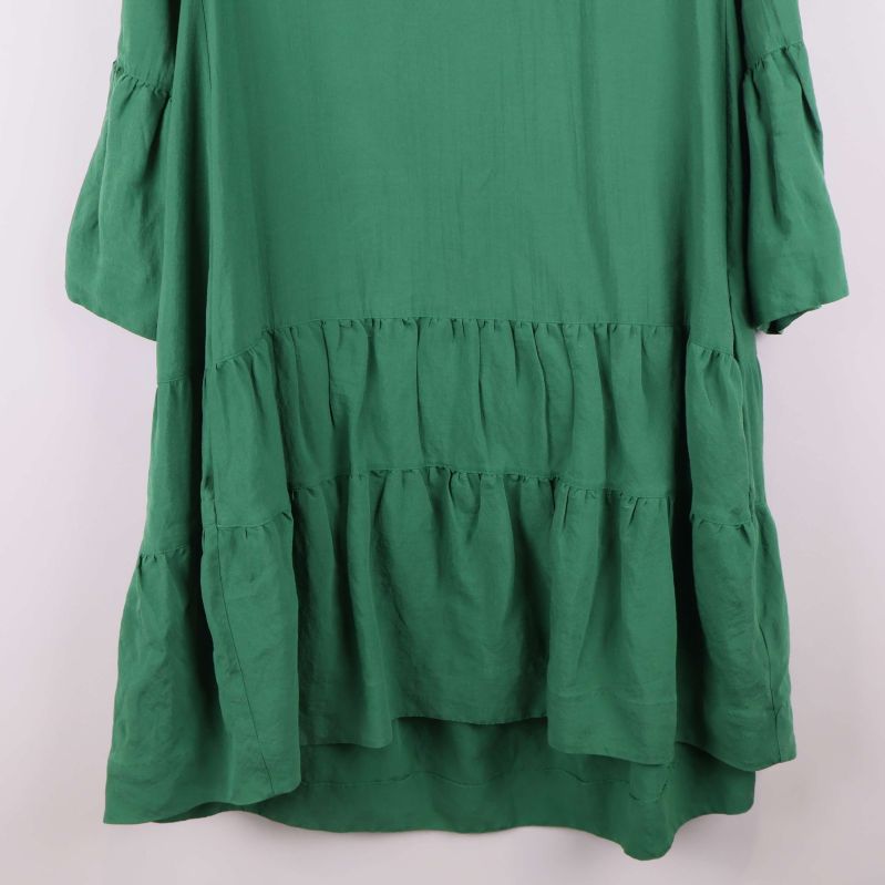 Närbild på volangdetaljer nedtill på klänningen