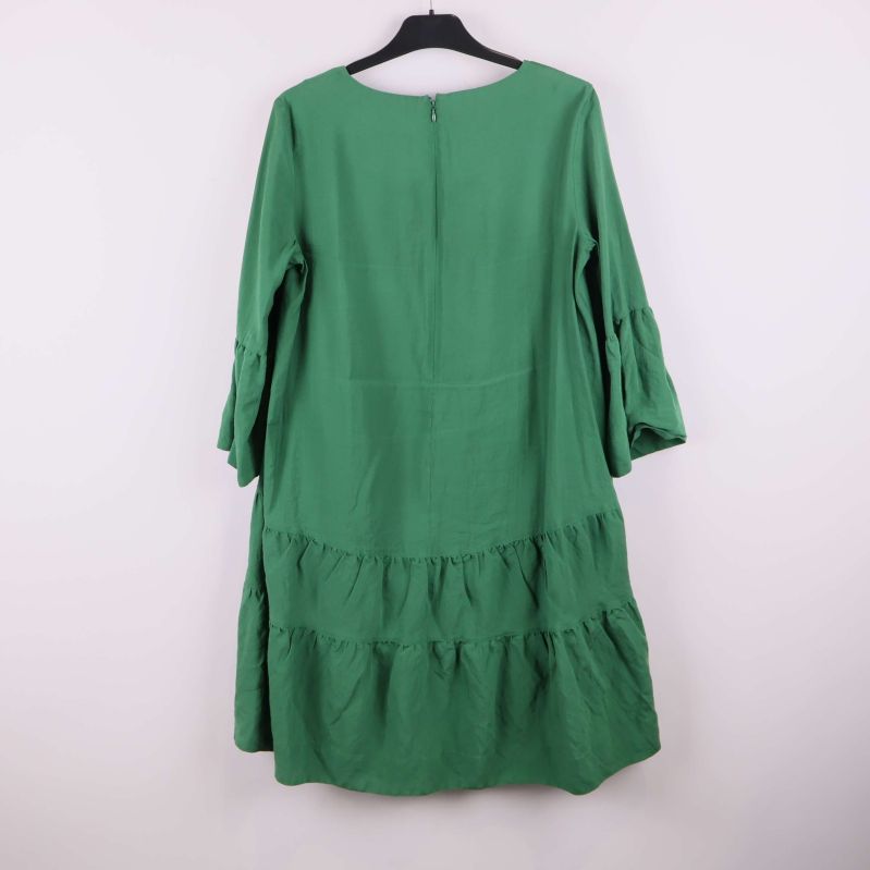 Grön klänning med volanger bakifrån 