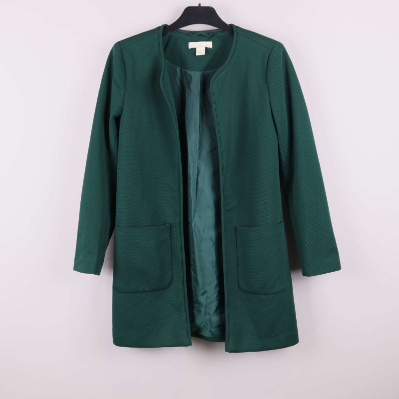 Framsidan av grön strukturerad jacka med fickor