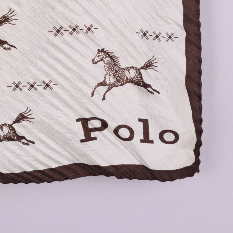 Närbild på scarf med bruna bokstäver Polo i hörnet