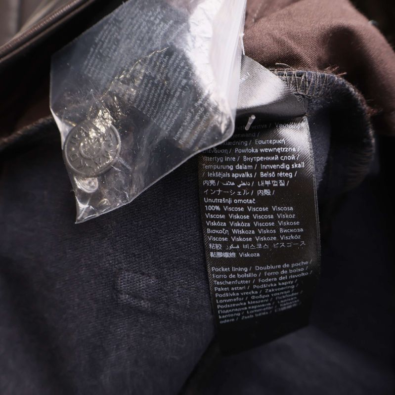 Materiallapp inuti bruna konstläderbyxor, visar material