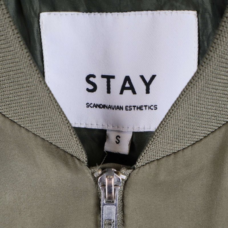 Närbild på STAY märkning i nacken av jackan