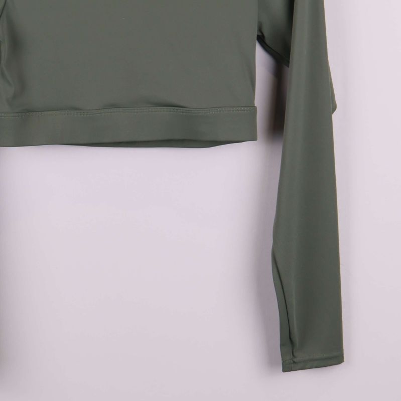 Närbild på ärm och nederkant av grön topp