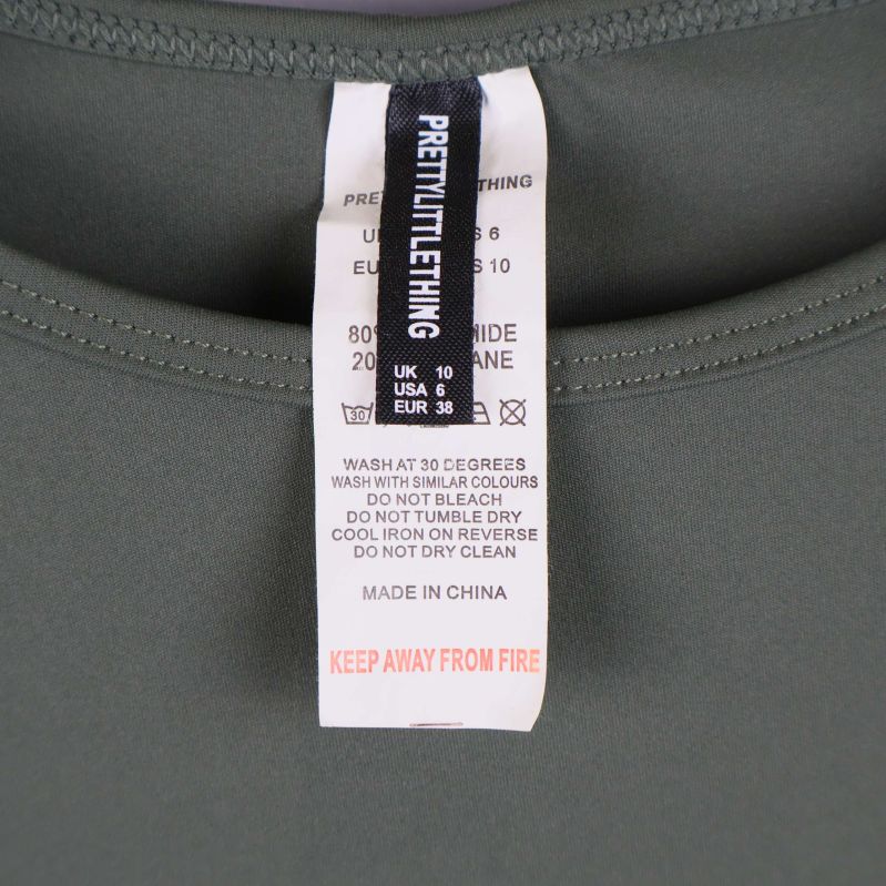 Material- och storleksetikett PrettyLittleThing på grön topp