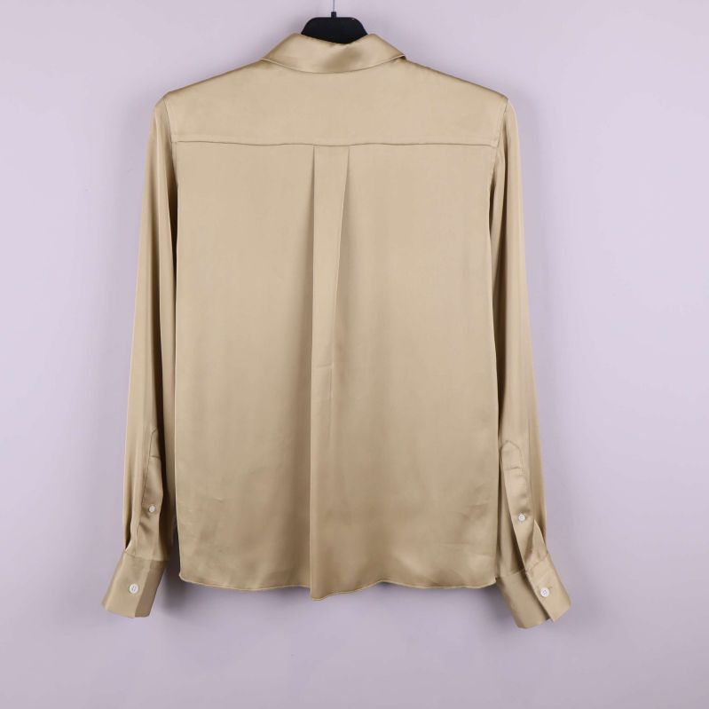 Baksidan av beige blus med breda manschetter