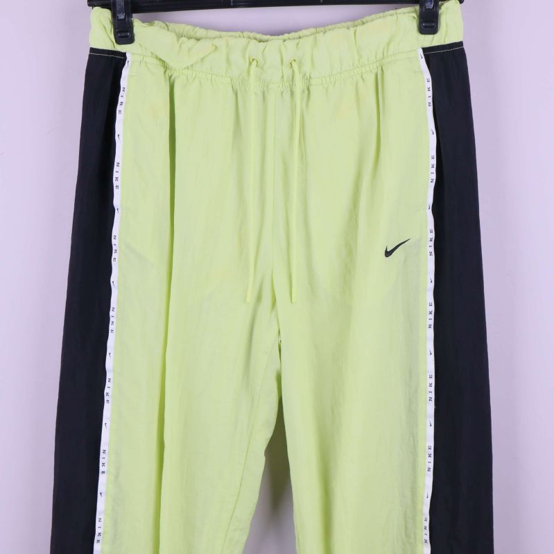 Närbild av midja och logga på ljusgrön träningsbyxa