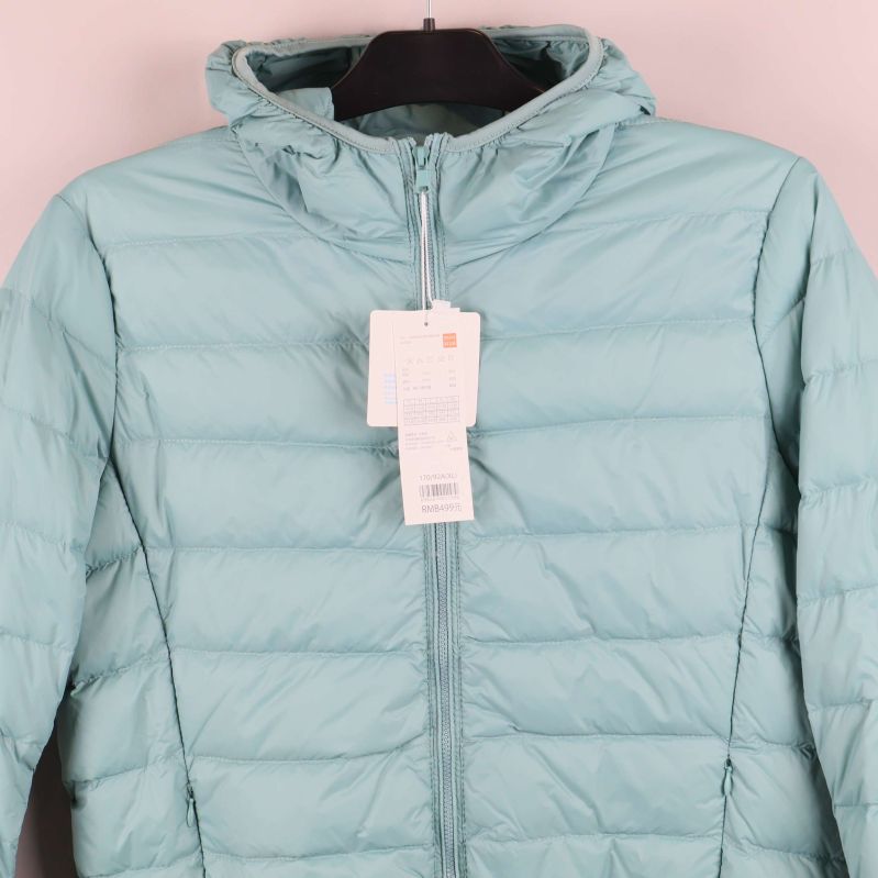 Närbild på huva och dragkedja på ljusblå jacka