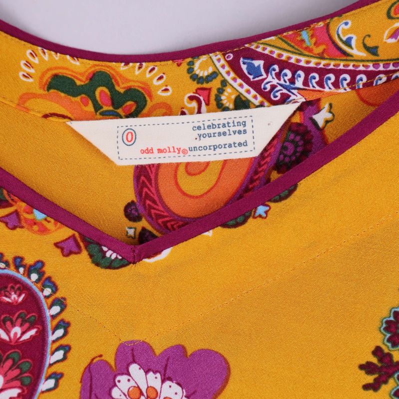 Närbild på Odd Molly-etikett i halsringning på klänningen