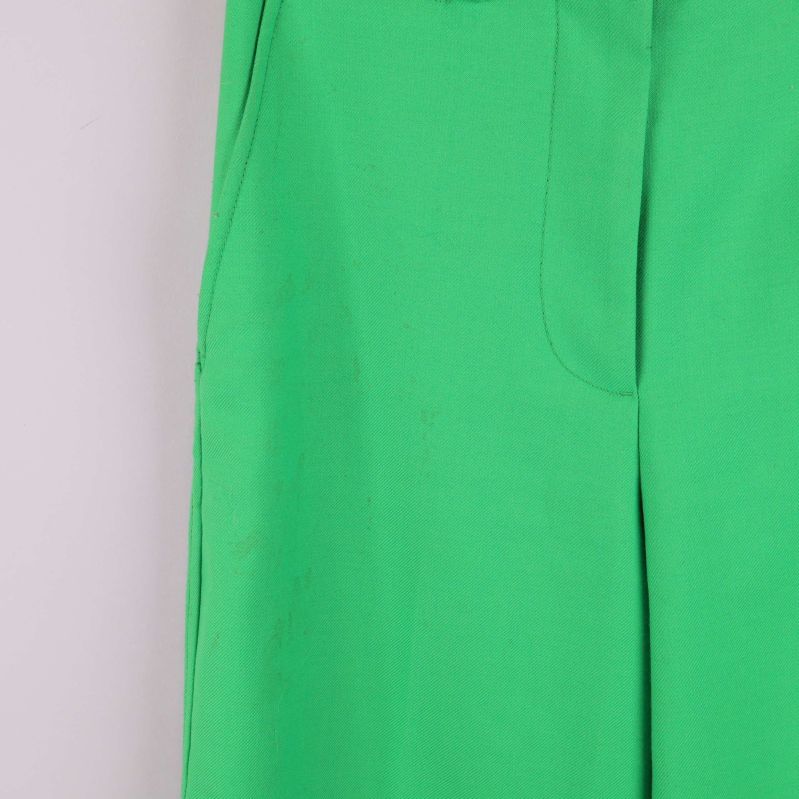 Liten fläck vid fickan på gröna raka byxor