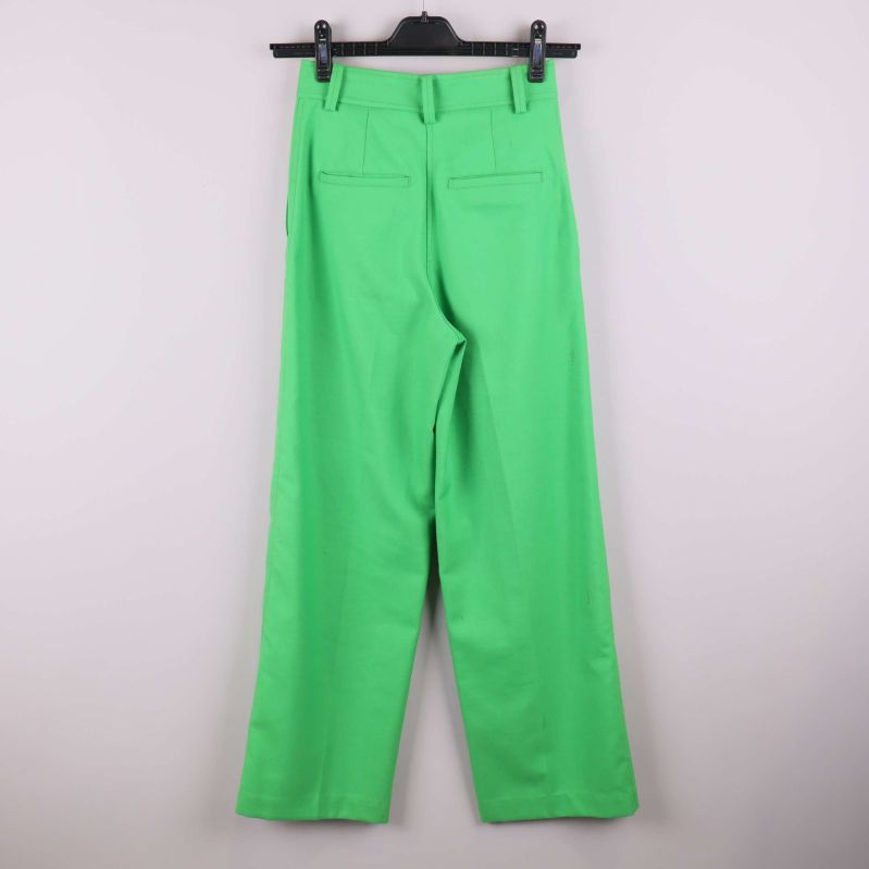 Baksida av gröna raka byxor hängande på galge