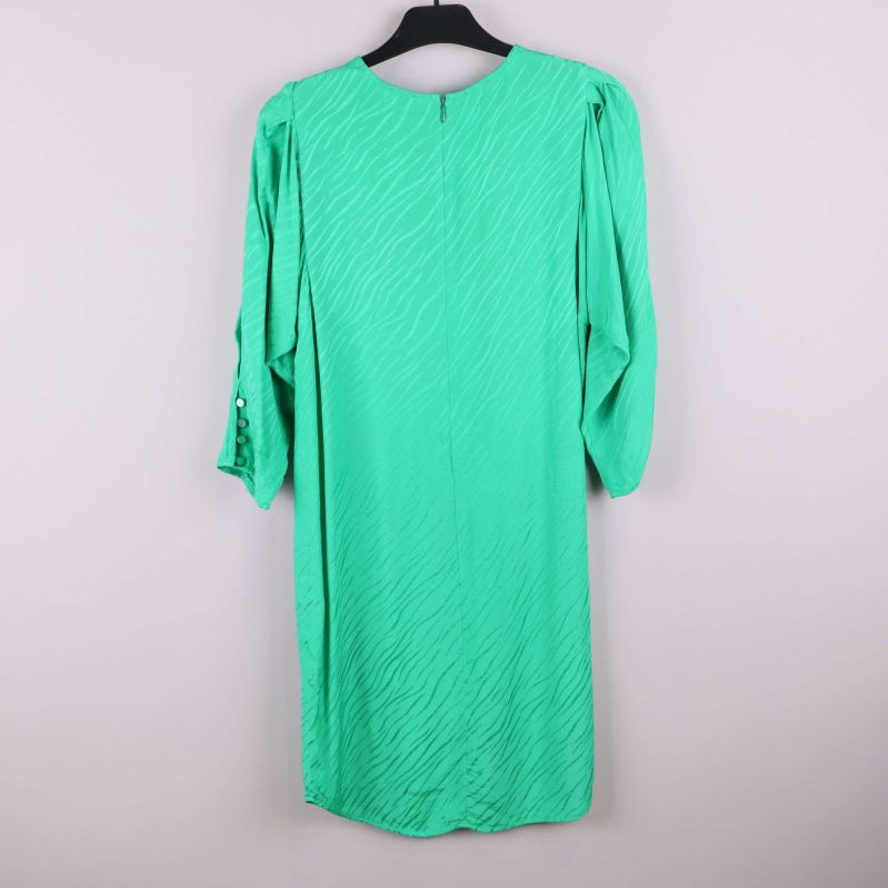 Grön klänning med strukturmönster sedd bakifrån