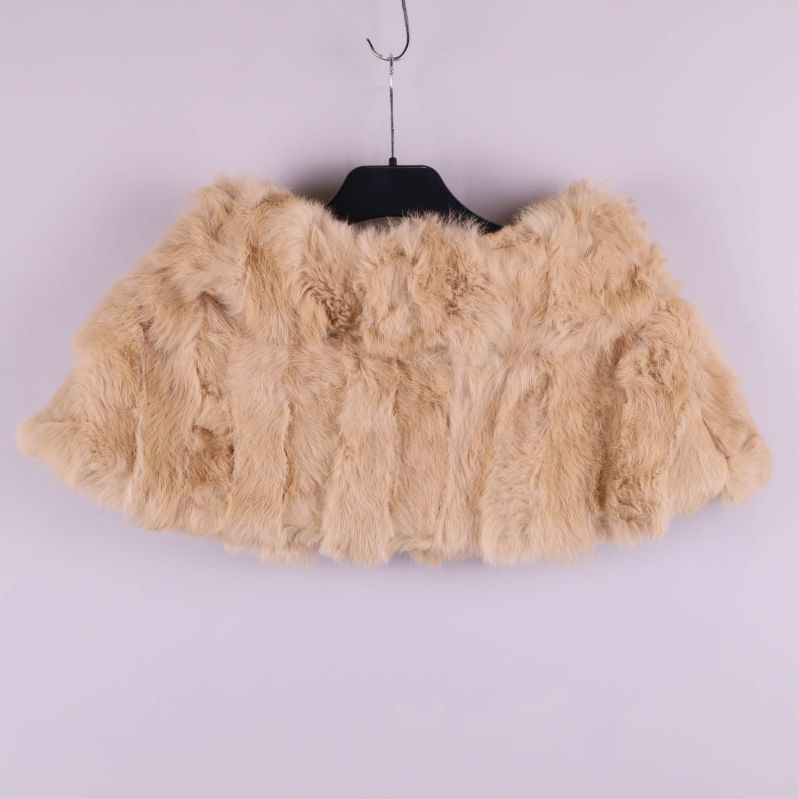 Baksida av beige pälsponcho på galge