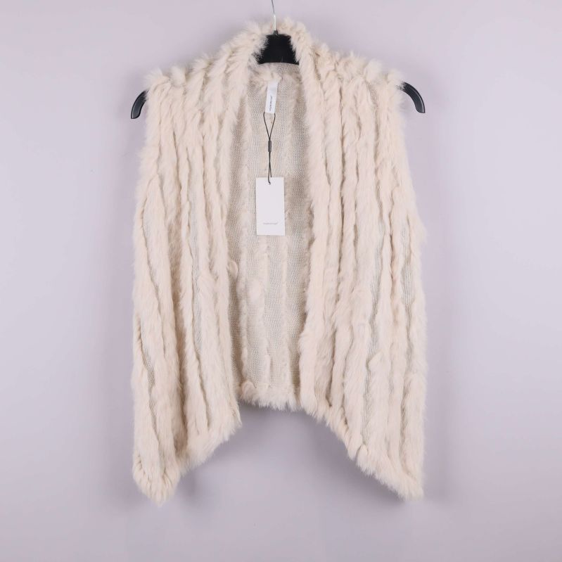 Krämvit väst med fuskpälsstruktur hänger på galge
