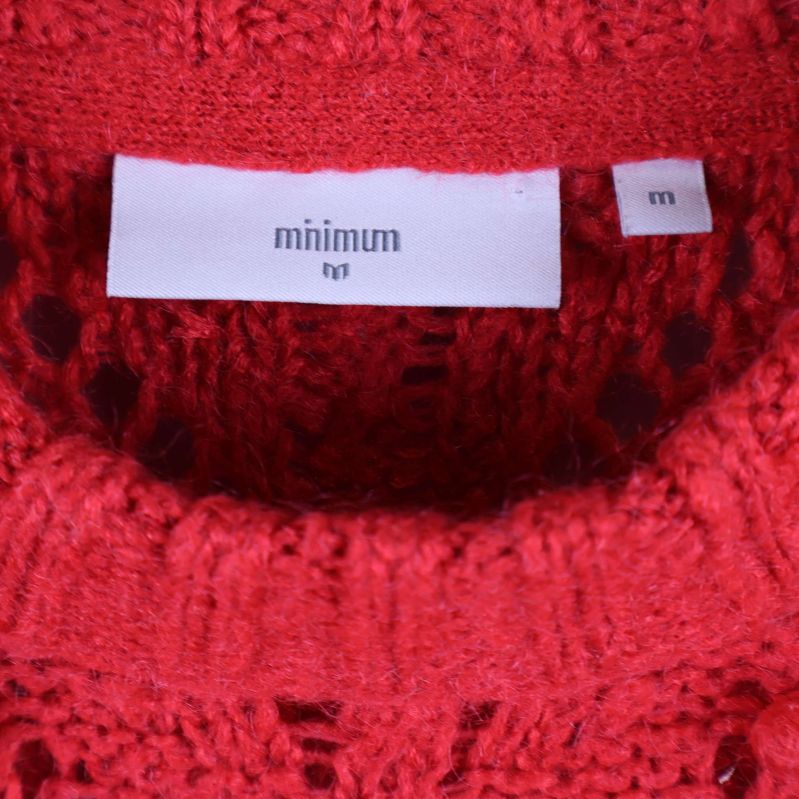 Minimum-varumärkesetikett i halsen på röd tröja