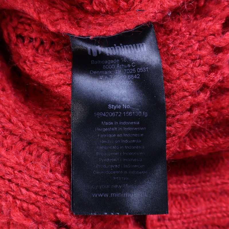 Material- och skötseletikett i röd tröja