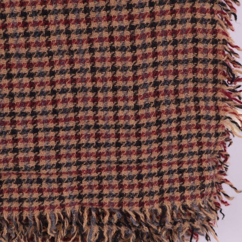 Detaljerad närbild av halsdukens hundtandsmönster och fransar