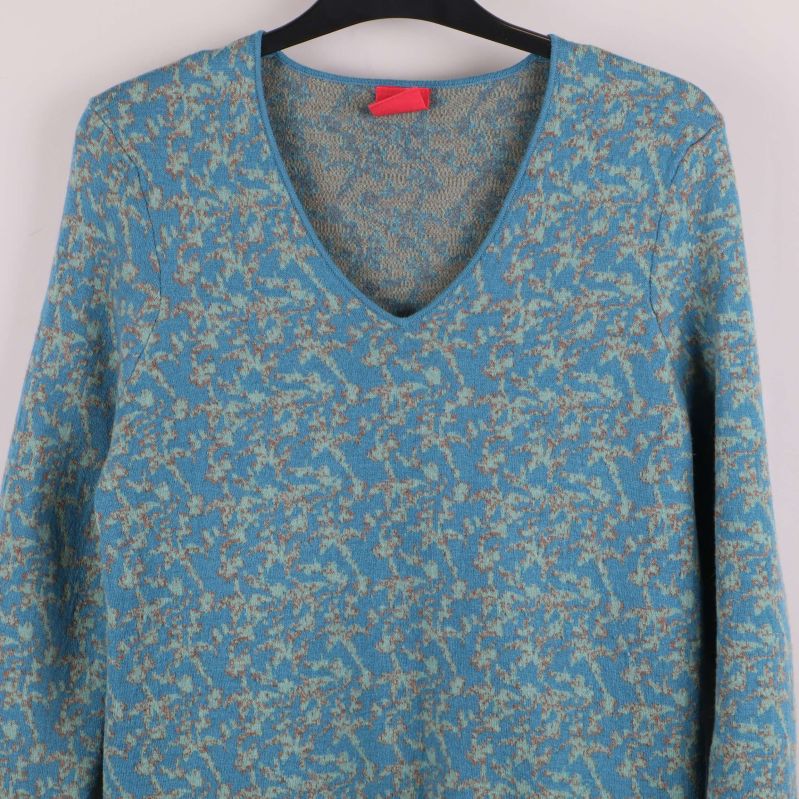 Närbild på V-ringning och blommönster på klänning