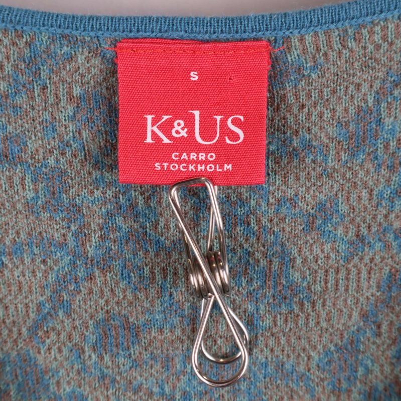 Närbild på röd K&US-etikett med storlek S i klänningen