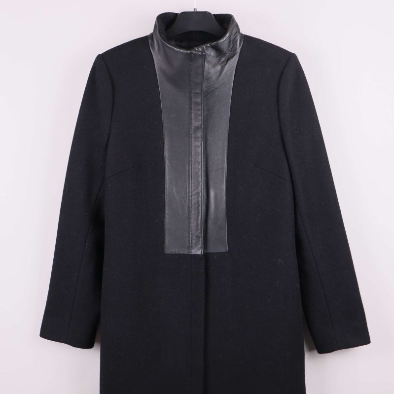 Detaljbild på krage och skinnimitation framtill på kappan