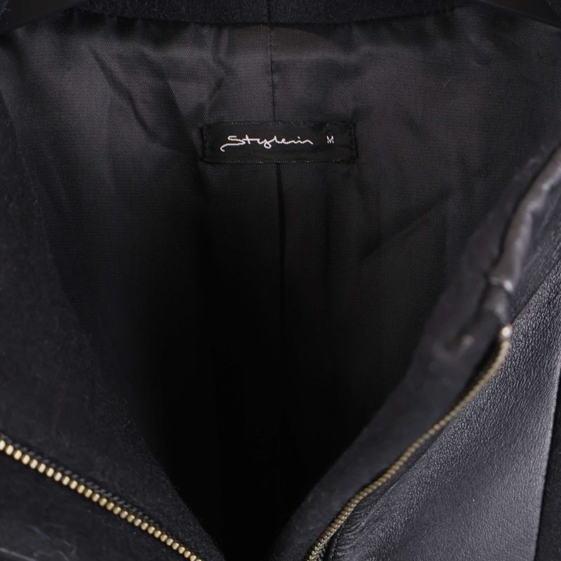 Närbild på etikett med Shafira-märke inuti kappan