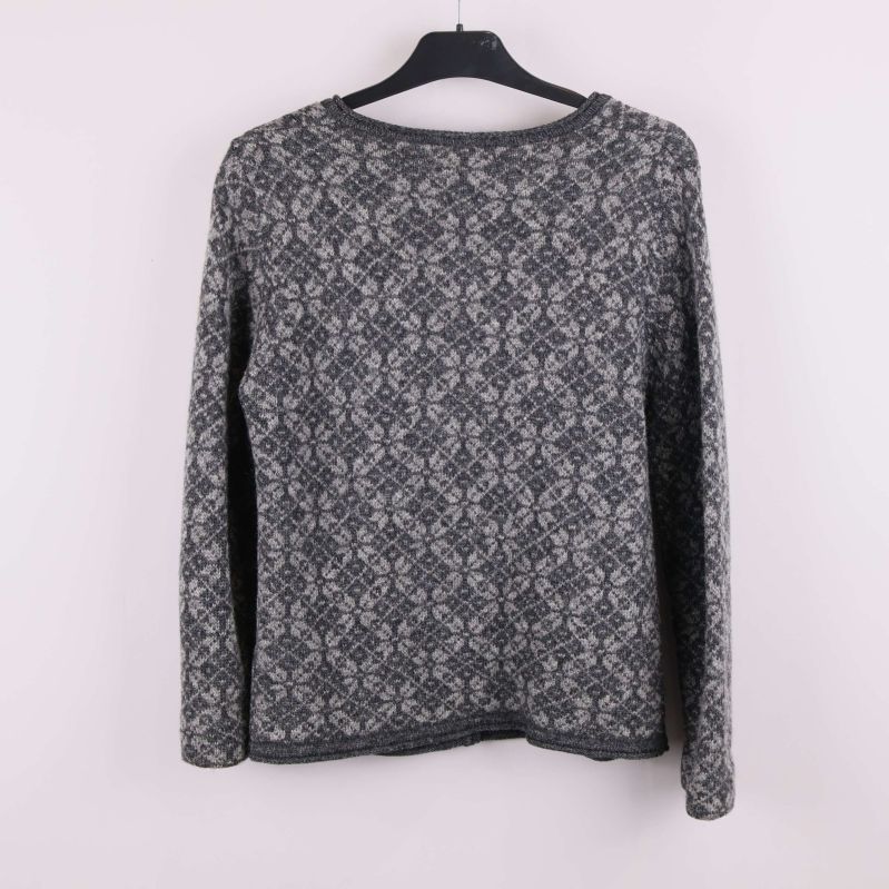 Baksida av grå jacquardmönstrad kofta på galge