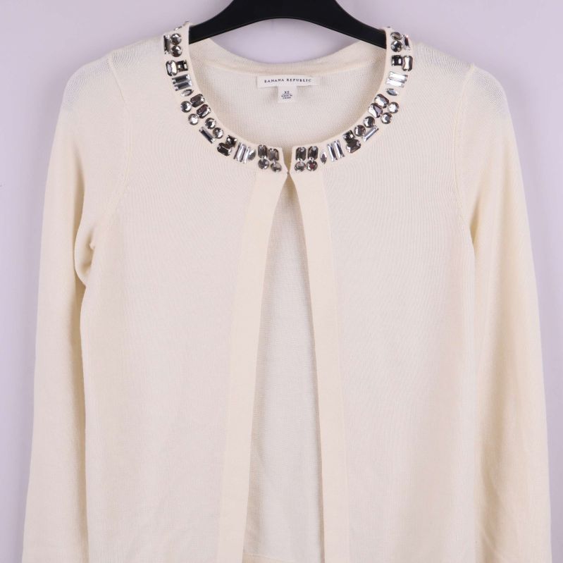 Kofta med dekorativa stenar kring halsen fotograferad framifrån