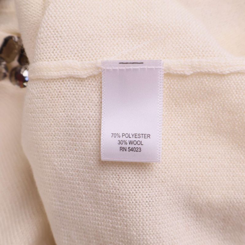 Materiallapp som visar 70% polyester, 30% ull