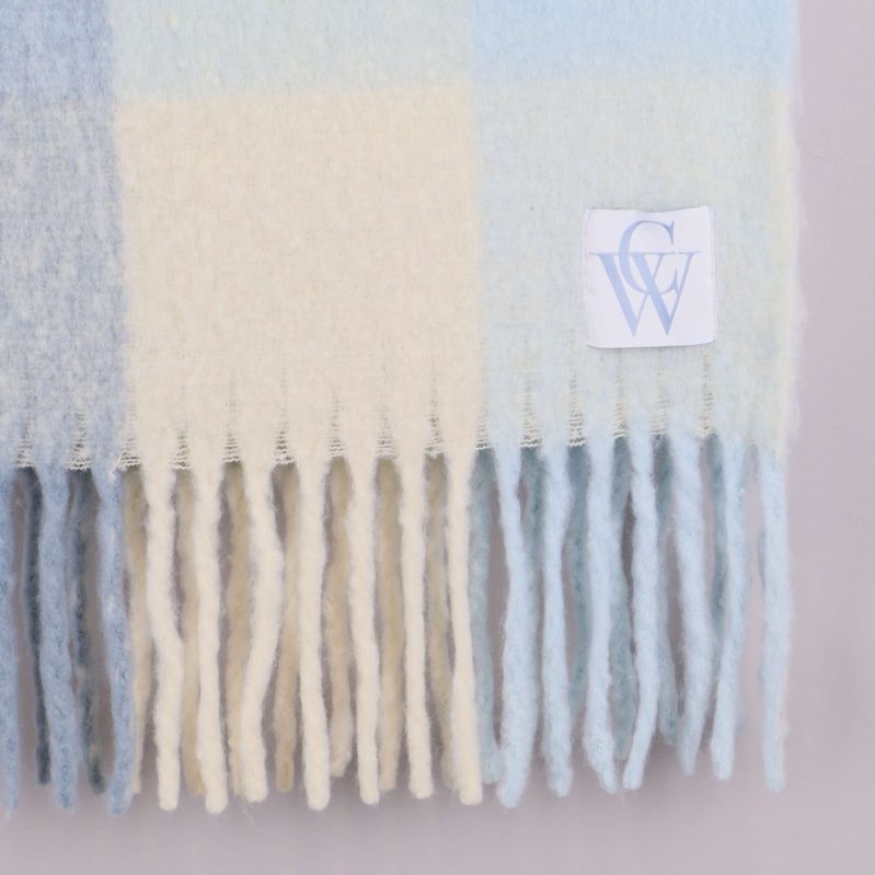 Närbild av halsdukens rutmönster och tyglogga