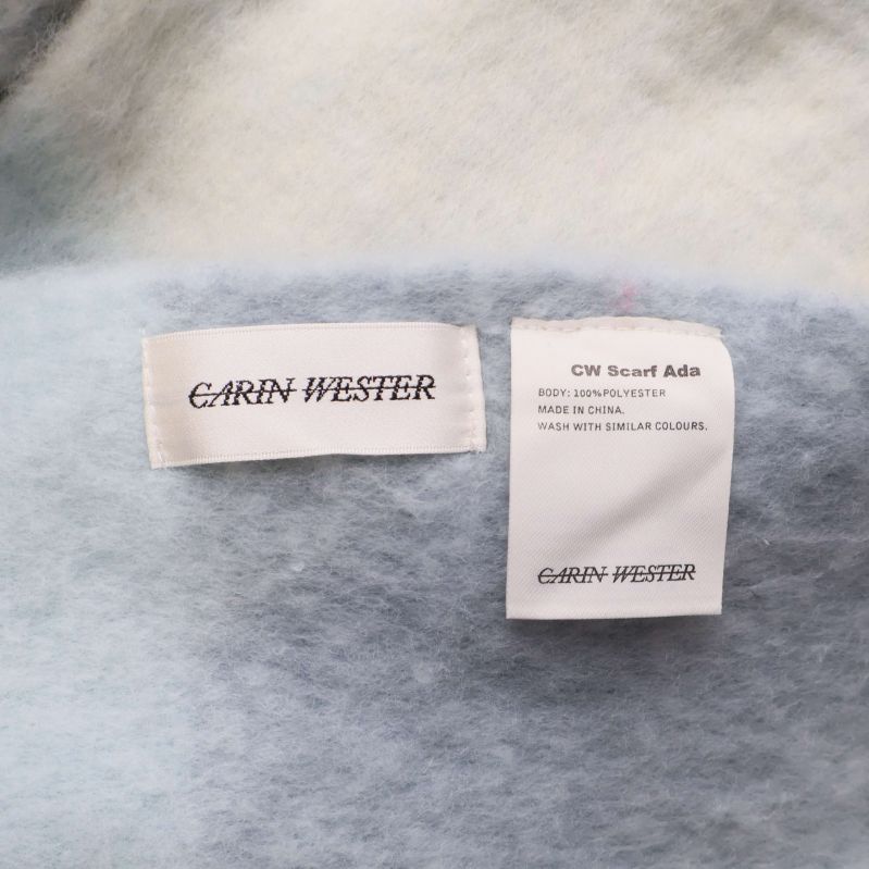 Två etiketter med Carin Wester och tvättråd på halsduk