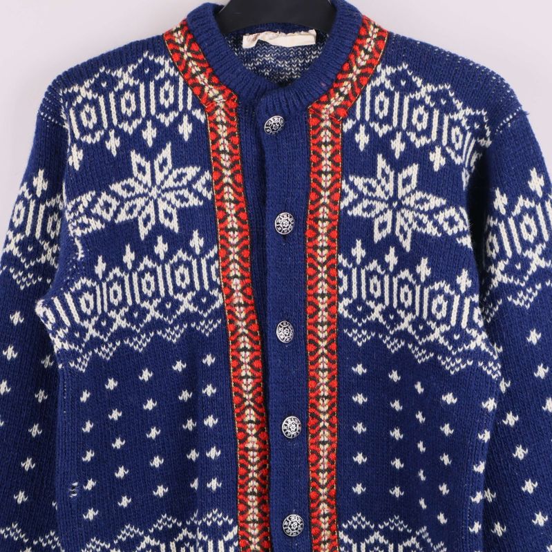 Närbild på koftans knäppning och röda kantdetaljer