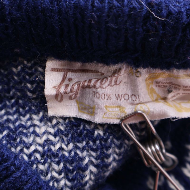 Nacketikett i kofta med märket Figuetti och materialinfo