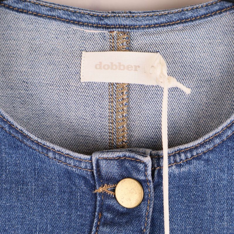 Halsringning och etikett i nacken på jeansklänning