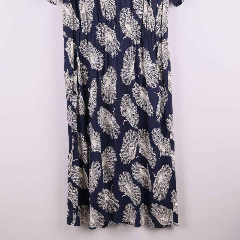 Nedre delen av klänning med vitt bladlikt mönster