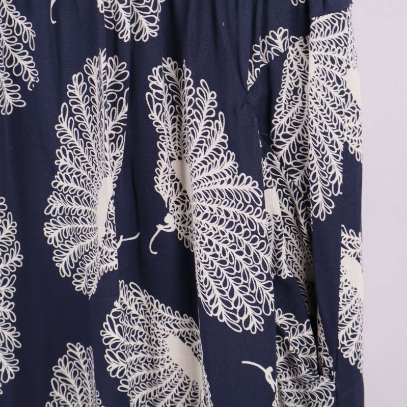 Närbild på vitt grafiskt bladlikt mönster på tyget