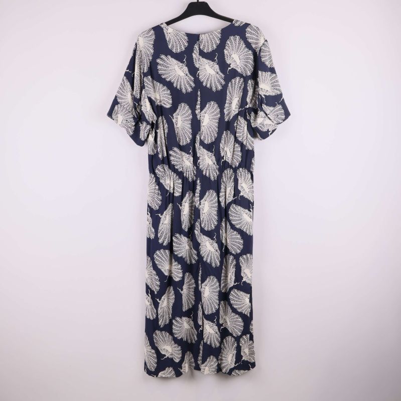 Lång klänning med vitt mönster på mörk bakgrund, baktill