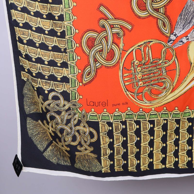 Närbild på hörn av scarf med Laurel-logga och tryck