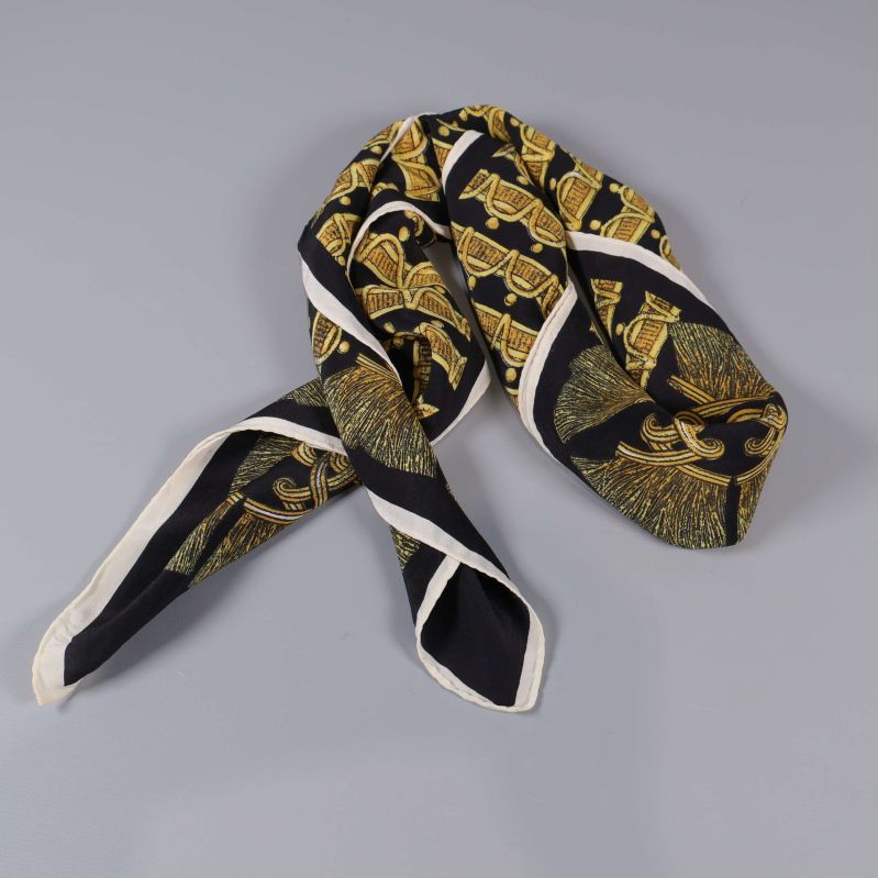 Svart och guldfärgad scarf vikt till smalt band