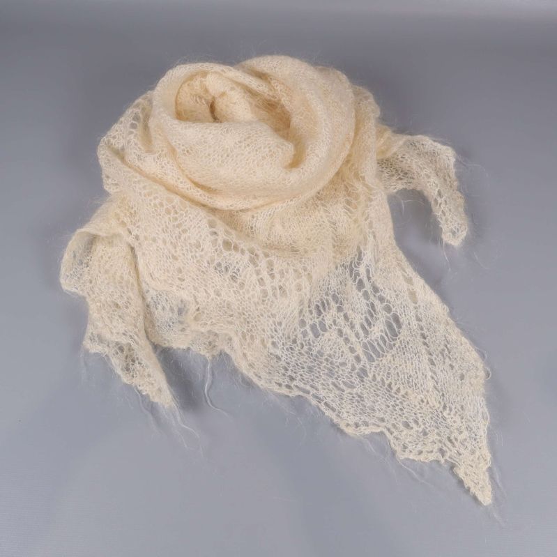 Ljus spetsstickad sjal draperad i cirkel på ett bord
