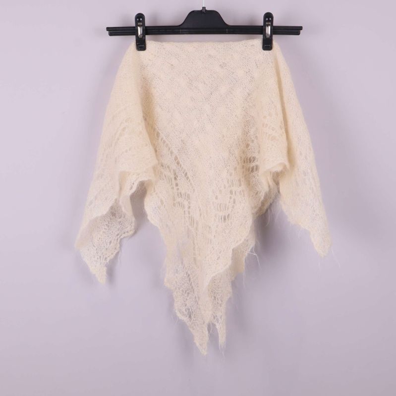 Ljus spetsstickad sjal hängande på galge