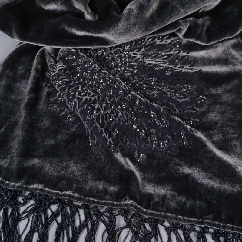 Närbild liggande scarf med glansig yta och broderi