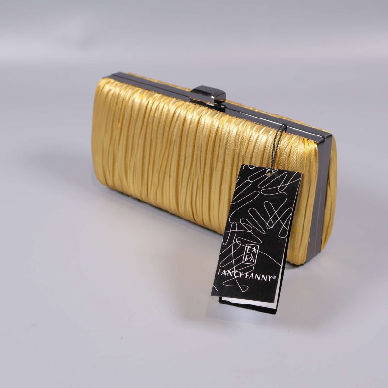 Guldig clutch med etikett placerad snett framifrån