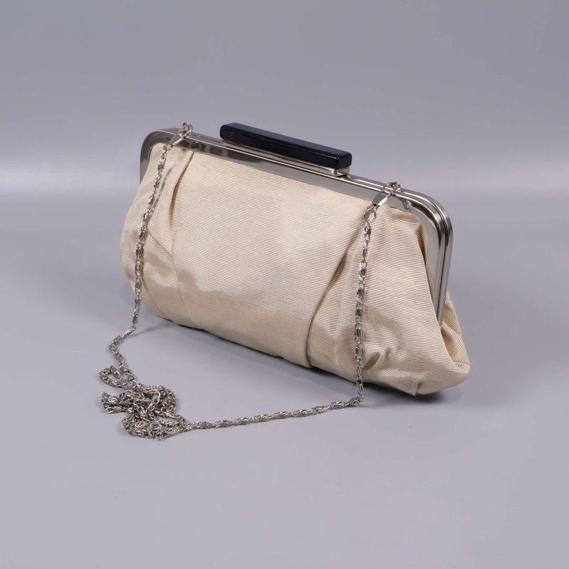 Beige kuvertväska med silverram och kedja på grå bakgrund