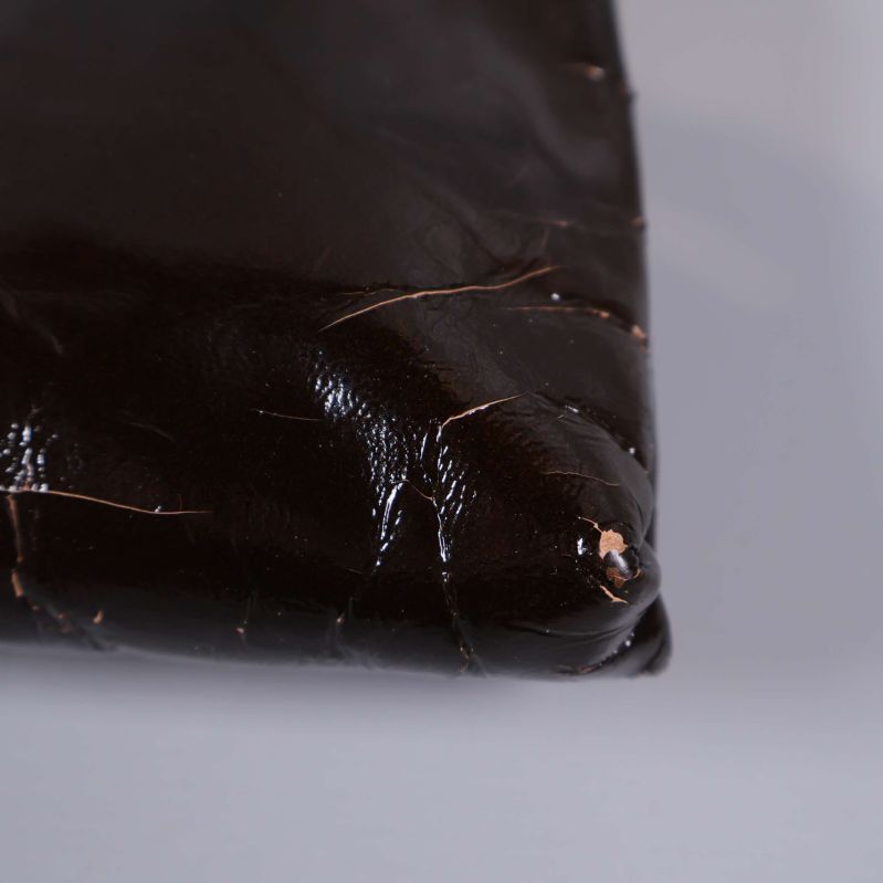 Närbild på hörn med slitage på brun väska