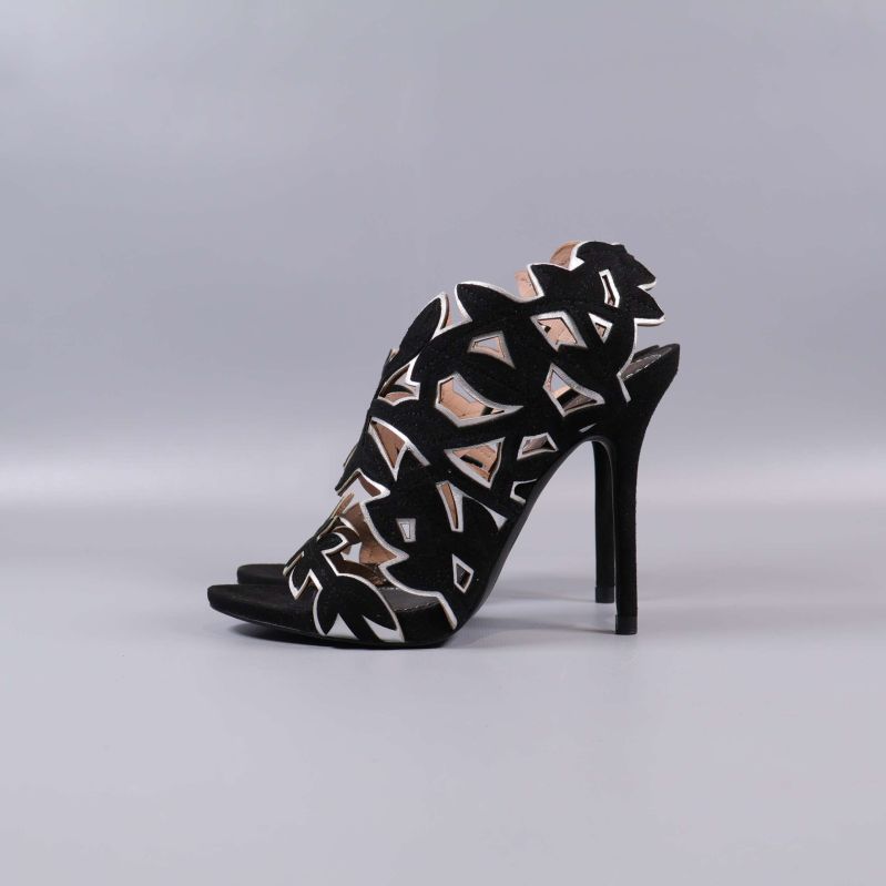 Sidovy av högklackad sandal med svart och beige mönster